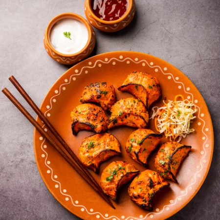 Tandoori momo, veg or non veg in red and cream sauce, served with sauce.  Nepal and Tibet recipe